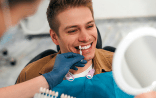 Teenage boy looking at different shades for teeth whitening