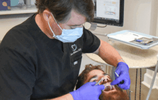 Dr. Eddleman working on a man's teeth, representing benefits of same-day crowns