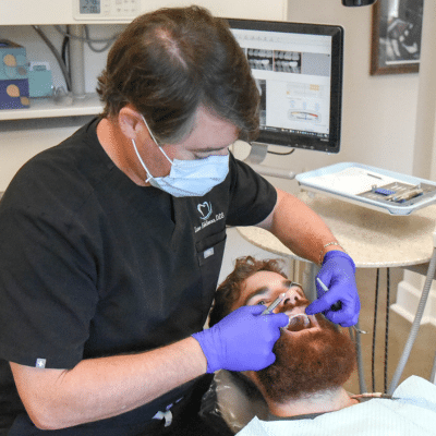 Dr. Eddleman working on a man's teeth, representing benefits of same-day crowns